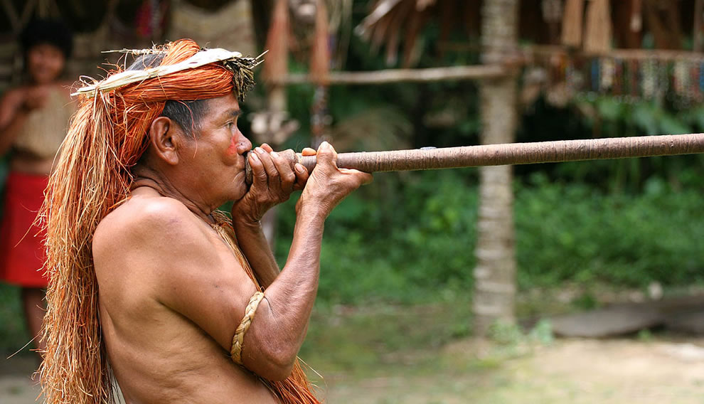 A Yagua (Yahua) tribeman demonstrating the use of blowgun (blow dart), at one of the Amazonian islands